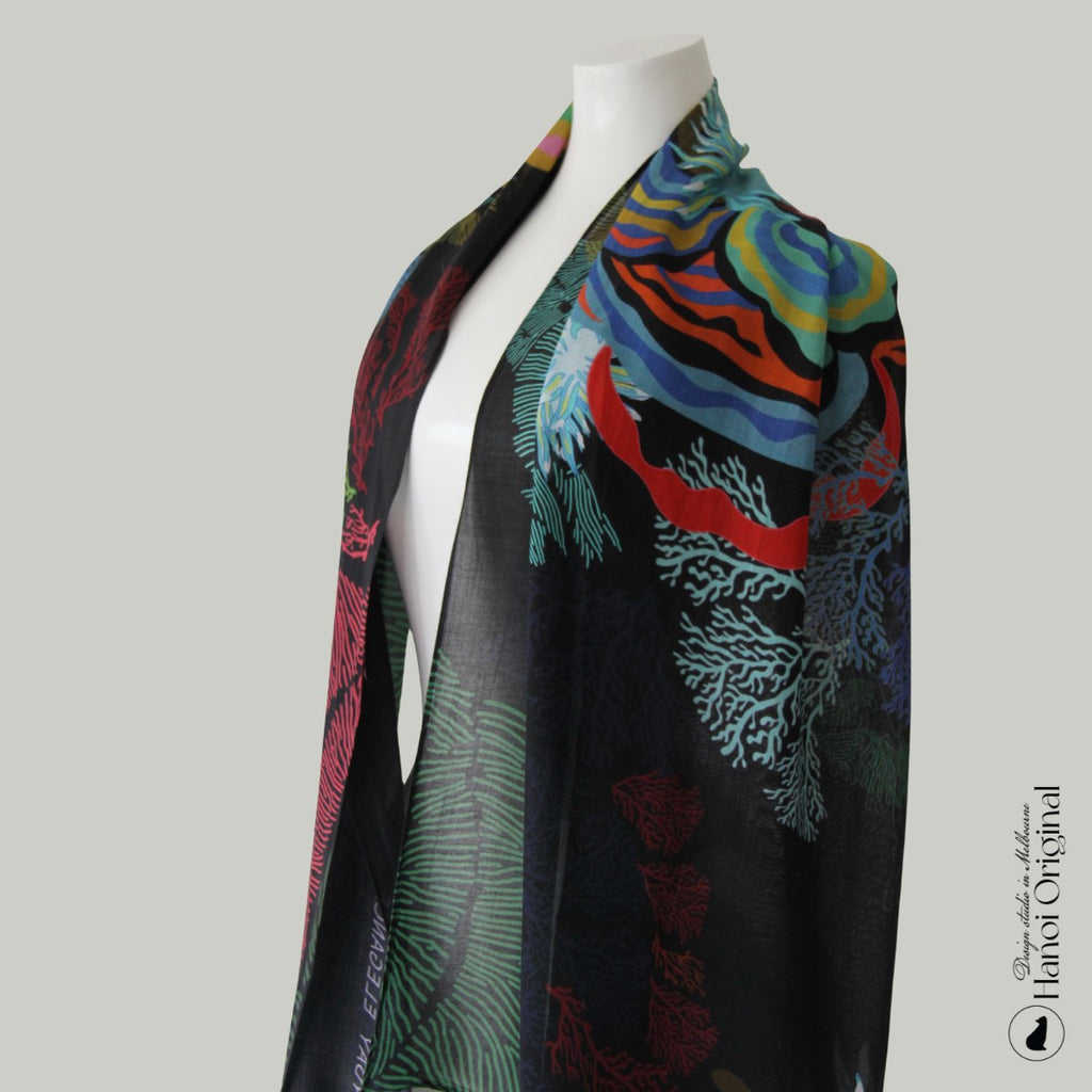 Colorful scarf with floral patterns on a mannequin against a gray background